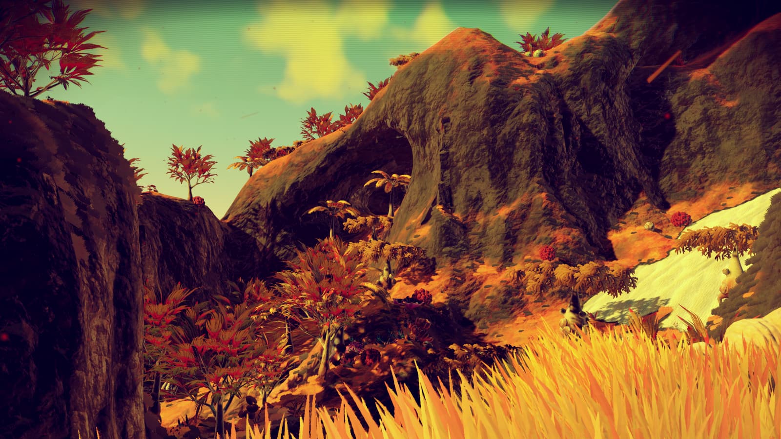 Photo of a craggy elevation on a golden lush world from No Man's Sky version 1.1